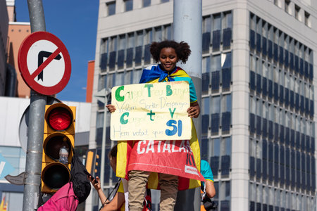 Barcelona, Catalonia / Spain - September 11, 2019: Catalan-african young girl holding a banner that claims that they are looking forward to leave Spain. Independentist rally at La Diada, Catalonia's National Day.のeditorial素材
