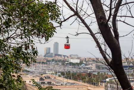 Iconic Barcelona's red aerial tramway moving over Port Vell. The red Funicular.のeditorial素材