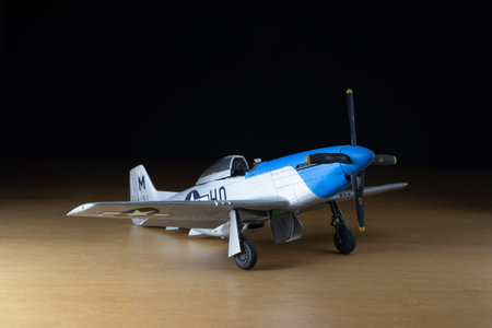 P-51 mustange scale aircraft model over wood with black background.のeditorial素材