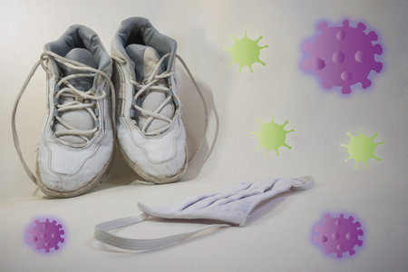 Sport shoes and a face mask with different purple and green virus around.の写真素材
