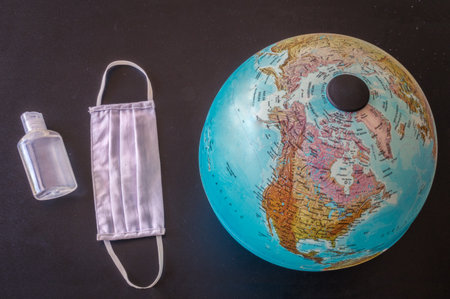 Photo of a mask, disinfectant and earth with a black backgroundの写真素材