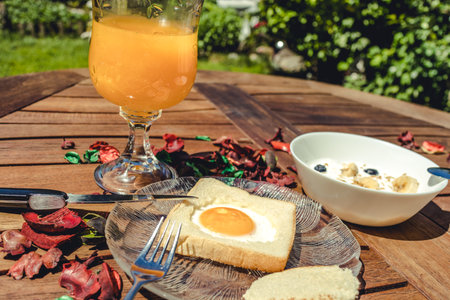 Close up photo of a delicious and stylish breakfast made of sandwich egg, fruit yogurt and orange juice.の写真素材