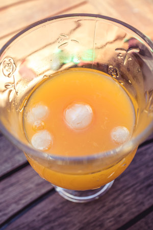 Fresh and cold orange juice on a glass cup with iceの写真素材