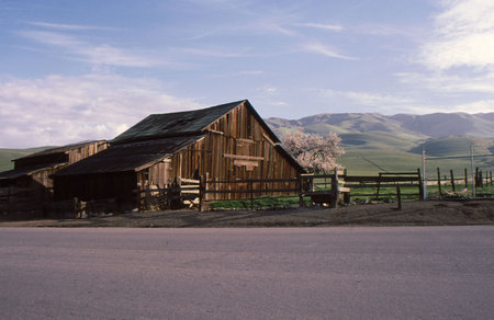 Old Barn in field on a country road with hills in backgroundの写真素材