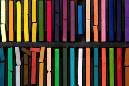 bars of bright and colorful pastel on black backgroundの写真素材