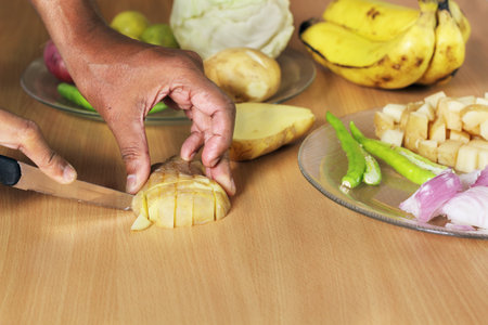 Slicing vegetables for the preparation of Indian curry の写真素材