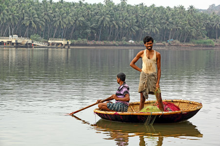 Goa, India - April 16, 2017: Local fishermen in coracle retrieve the trap net laid the previous night for catching fish in the Mondovi River in Old Goa, Indiaのeditorial素材