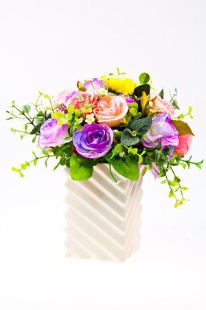 Colorful artificial beautiful flowers in a vase isolated on white backgroundの写真素材