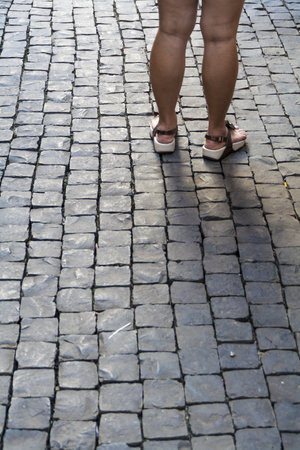 Conceptual image of woman standing on stone block pavingの写真素材