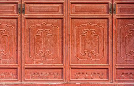 The antique red Chinese wooden carved doors of templeの写真素材