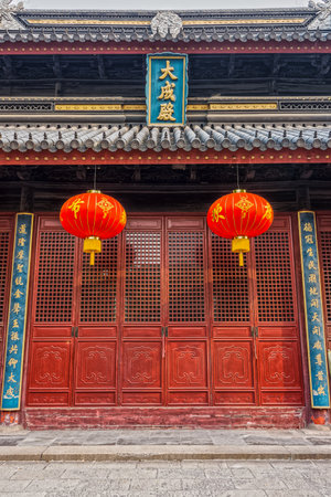 Red Chinese paper lanterns and wooden doors in front of Jiangyin Temple in Chinaのeditorial素材