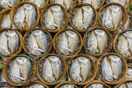 Steamed and salted Rastrelliger brachysoma (Short mackerel)  are packed in bamboo baskets for sale in Thai fresh marketの写真素材