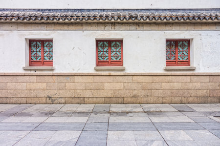 The vintage windows, roof, concrete wall and pavement of antique Chinese building in Chinaの写真素材