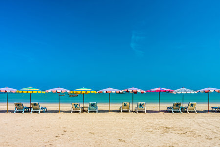 Beach umbrellas and sunbathe seats on Phuket sand beach in Southern Thailandのeditorial素材