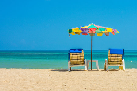 Beach umbrellas and sunbathe seats on Phuket sand beach in Southern Thailandのeditorial素材