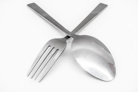Stainless steel spoon and fork isolated on white backgroundの写真素材