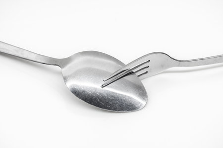 Stainless steel spoon and fork isolated on white backgroundの写真素材