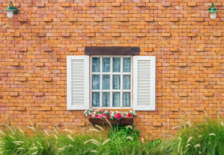 Vintage white window on brick wall with hanging lamp and flowers in flowerpot. This architecture is European styleの写真素材