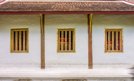 Concrete wall and wooden windows of Buddha image hall of Wat Phra Sing Wora Maha Wihan. Wat Phra Sing is a Buddhist temple in Chiang Mai province, Northern Thailand.の写真素材