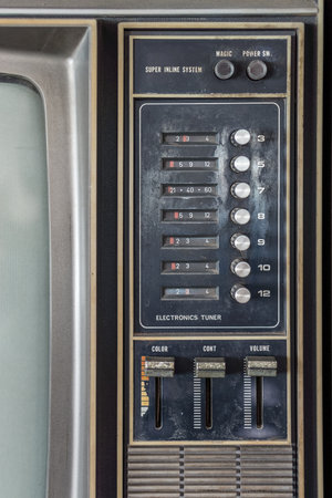 Control panel of old classic color analog television. It has channel selector dials, push power switch and set of volume, color, contrast, brightness adjustment control.の写真素材