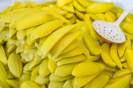 Heap of sweet sliced pickled mango fruits for retail sale in Thailand food market. They are fruit preserves for long-term storage.の写真素材