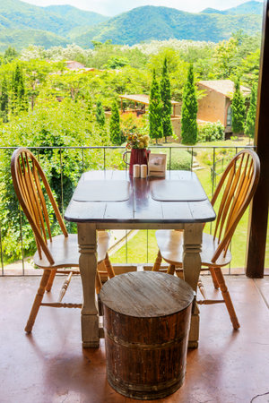 Vintage wooden table and chair on terrace with mountain view. The decoration of a restaurant.の写真素材