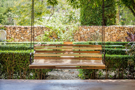Vintage wooden hanging seat on an airy porch. It brings a feeling of well-being and relaxation.の写真素材