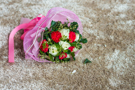 Wedding flower bouquet on carpet. The flowers are red and white roses.の写真素材