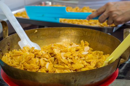 Corn flakes in cooking before mixing with caramel. They are made by toasting flakes of corn.の写真素材