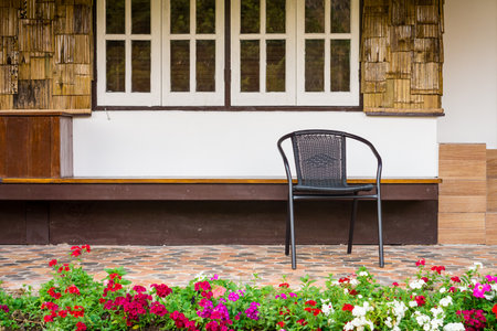 Alone black chairs at a home paving porch. It is made of metal rod and weave structure.のeditorial素材