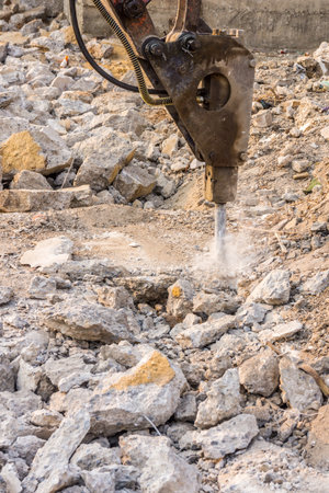 Hydraulic breaker is demolishing concrete structures. It is mounted on an excavator.