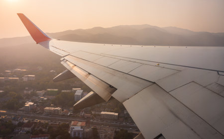 Airplane wing with mountain and city from aerial view. The aircraft taking off from International...