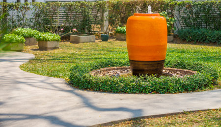 Orange water fountain jar for decoration in garden. It is an earthenware.の写真素材