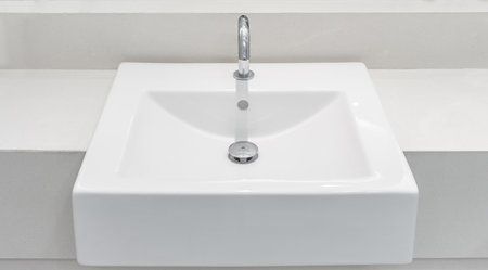 White ceramic wash basin with a automatic tap and drain. It is also known as sink, sinker, washbowl...