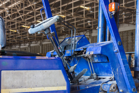 Old lift truck cab in industrial warehouse. The vehicle is also called forklift or fork truck.