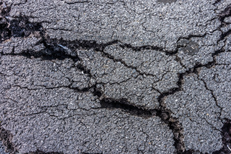 Texture of cracked asphalt pavement. It was greatly damaged by natural disasters.の写真素材
