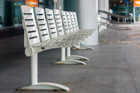 Modern seating at bus stop. The white seats are made of metal.の写真素材