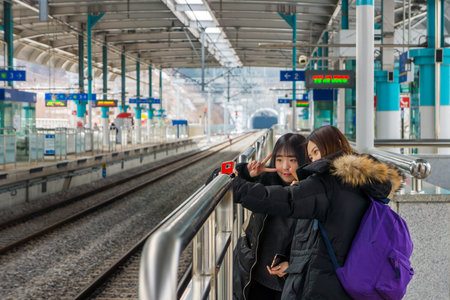 GYEONGGI, SOUTH KOREA - FEB 7, 2017: Two cute young Korean girls are taking selfie at Gapyeong Station before going to Namiseom Island in Gapyeong-gun.のeditorial素材