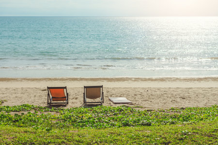 Beach chairs and a sunbed on a beach. With a warm sun and a gentle breeze for rest and relaxation.の写真素材