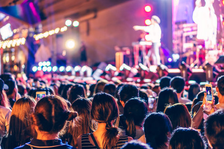 Audience at live concert. Crowd in front of stage at music festival.の写真素材