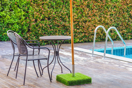 Modern table and chairs on decks at the side of swimming pool. For relaxation and recreation in hotel resort.の写真素材