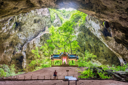 Khuha Kharuehat Throne in the center of cave's chamber with tourist woman. The tourist attraction at Phraya Nakhon cave in Khao Sam Roi Yot National Park, Prachuap Khiri Khan, Thailand.の写真素材