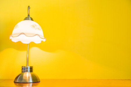 Vintage lamp on wooden table in yellow room. The lighting in romantic bedroom.の写真素材
