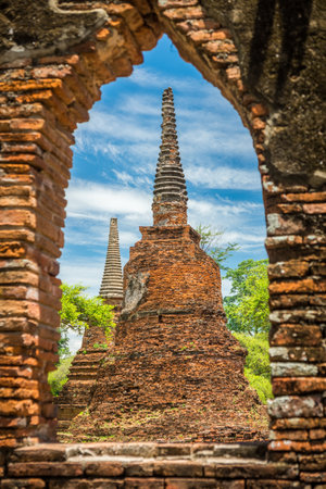 Two ancient remains pagodas looked through ruin window in Wat Phra Si Sanphet, Ayutthaya, Thailand. It is built in the classic, Ceylonese design or bell shape.の写真素材