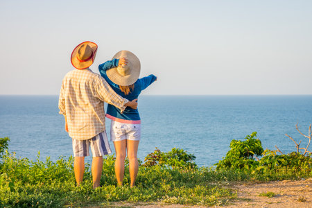 Sweet couple sitting and embracing each other on stone fences. The tourists go sightseeing at park for recreation.の写真素材