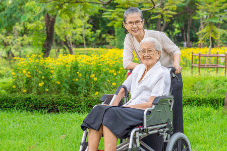 Happy senior daughter and her mother are smiling in garden. They are Asian peoples in Thailand.の写真素材
