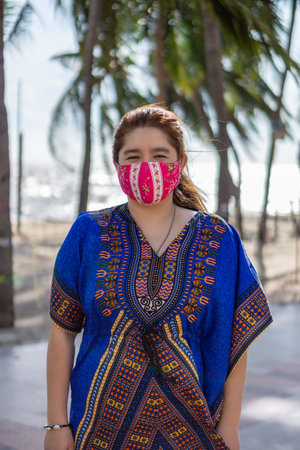 Woman wearing a pink fashion face mask to prevent COVID-19. It is a DIY mask made of cloth floral pattern.の写真素材