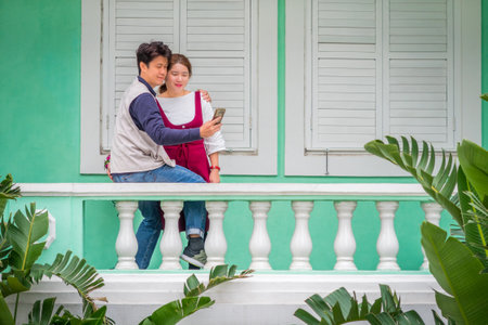 Happy man and woman are taking their pictures with mobile phone. They are at Taipa House Museum in Macau.の写真素材