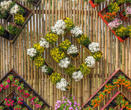 Flowers wall hanging in garden. Decorated bamboo wall with flowers in flowerpots.の写真素材