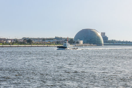 Boat running in front of Osaka Maritime Museum Dome. This area is located at Osaka bay in Japan.のeditorial素材